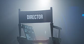 Chair of director with clapboard in spotlight