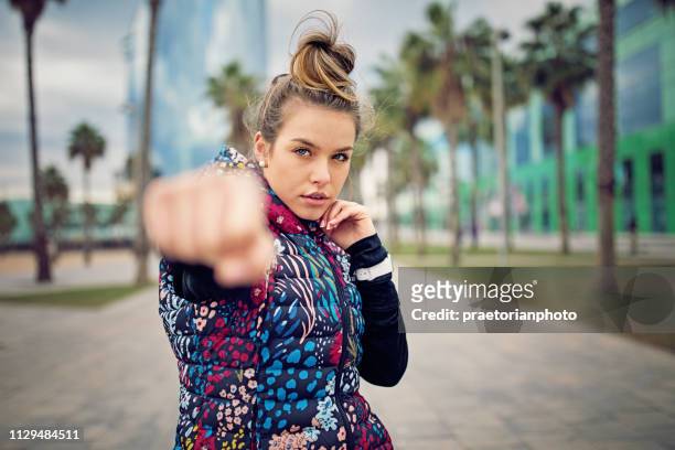 chica corredor es el boxeo a lo largo de la playa después de un largo recorrido - combat sport fotografías e imágenes de stock