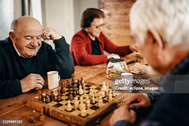 thinking about next move - senior playing chess stock pictures, royalty-free photos & images