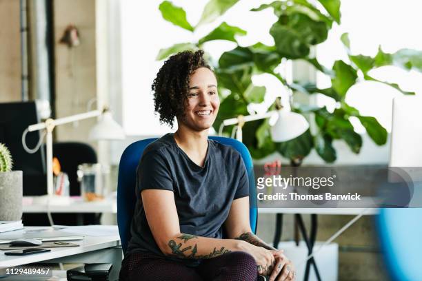 Portrait of smiling businesswoman seated at workstation in design office