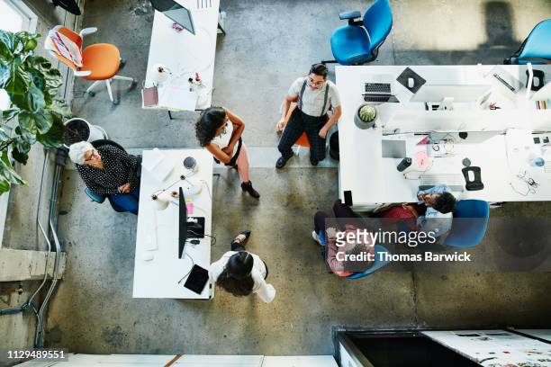overhead view of design team having project meeting in office - elevated view stock-fotos und bilder