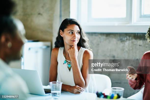 smiling businesswoman listening to coworker during meeting in conference room - group people thinking stock pictures, royalty-free photos & images
