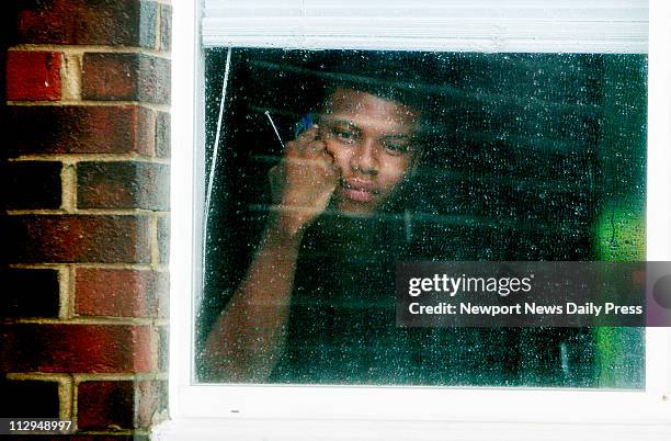 Kareem Jones, a resident at Mariner's Landing apartments in Newport News, Virginia, watches his neighbors evacuate while he talks on the phone in his...