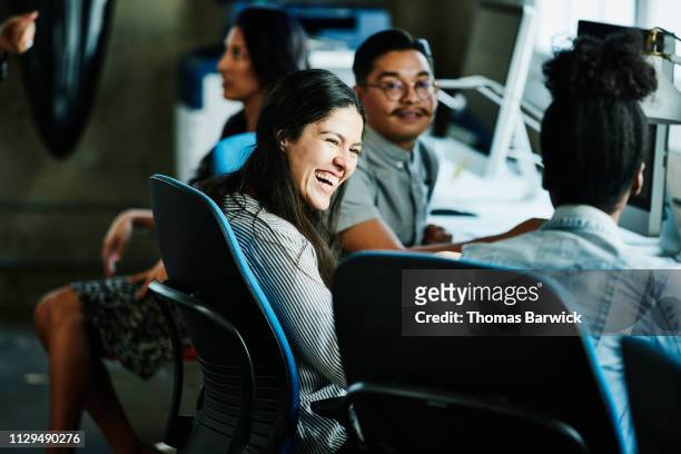 Businesswoman laughing with coworkers while working in design studio