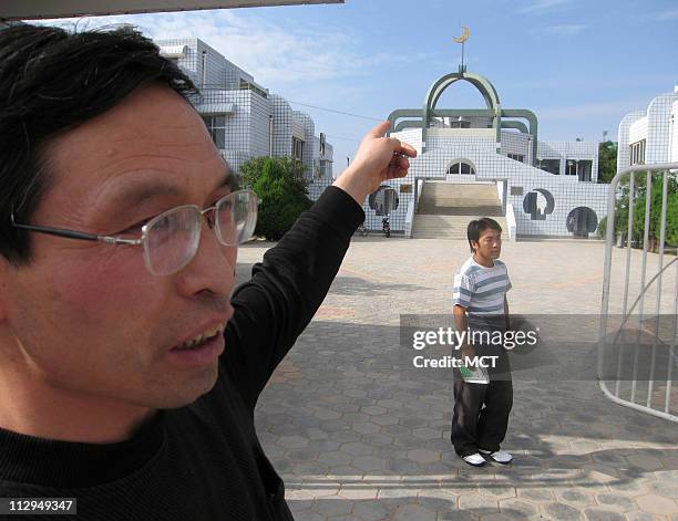 An official at the Tongxin Arab Language College, Chen Jianyi, points to the mosque that is at the center of the institution. The college is in...