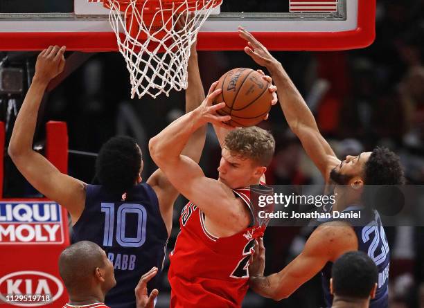 Lauri Markkanen of the Chicago Bulls rebounds between Ivan Rabb and Tyler Dorsey of the Memphis Grizzlies at the United Center on February 13, 2019...