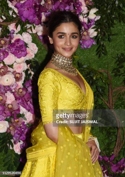 Bollywood actress Alia Bhatt poses for photographs as she arrives to attend the wedding ceremony of Akash Ambani, son of Indian businessman Mukesh...