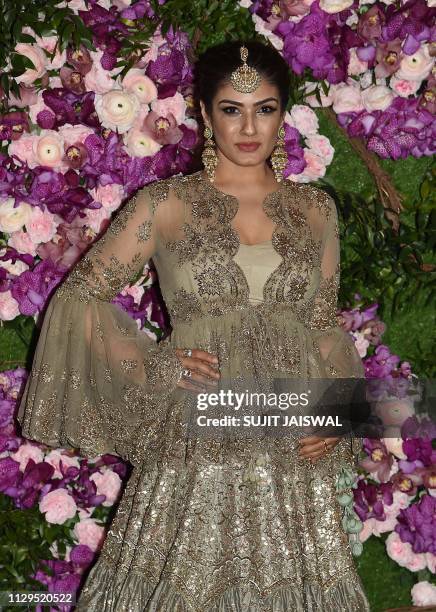 Bollywood actress Raveena Tandon poses for photographs as she arrives to attend the wedding ceremony of Akash Ambani, son of Indian businessman...