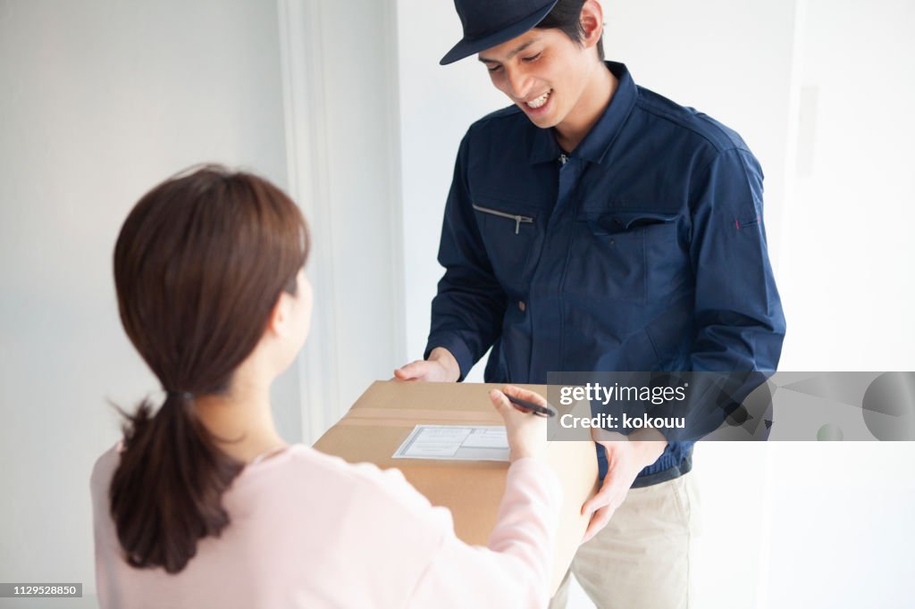 Delivery Others The Delivery Member Delivers The Cardboard Box To The Woman High-Res ...