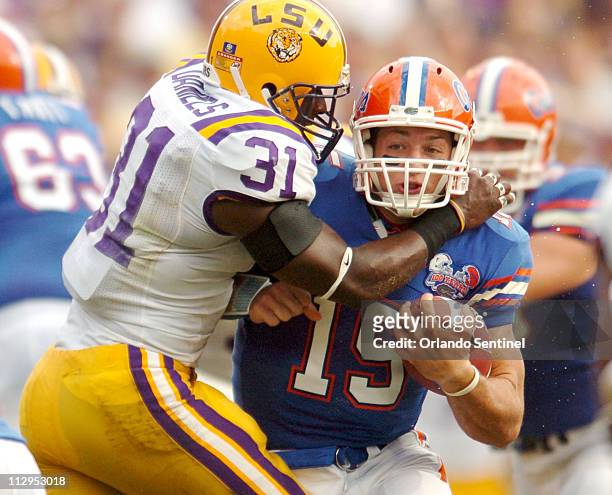 Florida quarterback Tim Tebow runs in the grasp of Louisiana State safety Jessie Daniels at Ben Hill Griffin Stadium in Gainesville, Florida,...