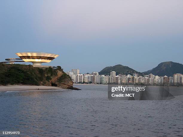 The distinctive Museum of Contemporary Art illuminates the skyline October 15 in Niteroi, Brazil. Legendary Brazilian architect Oscar Niemeyer...