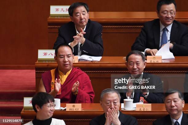 The Chinese government-selected 11th Panchen Lama Gyaincain Norbu applauds during a plenary session of the Chinese People's Political Consultative...