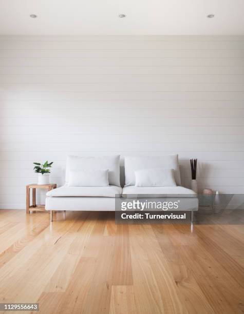 woonkamer witte bank hout vloer - vloerbedekking stockfoto's en -beelden