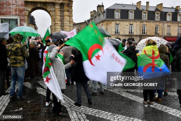 Demonstrators hold Algerian and Amazigh flags on the Place de la Victoire in Bordeaux, southwestern France on March 10, 2019 in support of the...