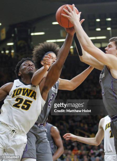 Forward Tyler Cook of the Iowa Hawkeyes battles for a rebound in the second half against forward Miller Kopp and center Barret Bensin of the...