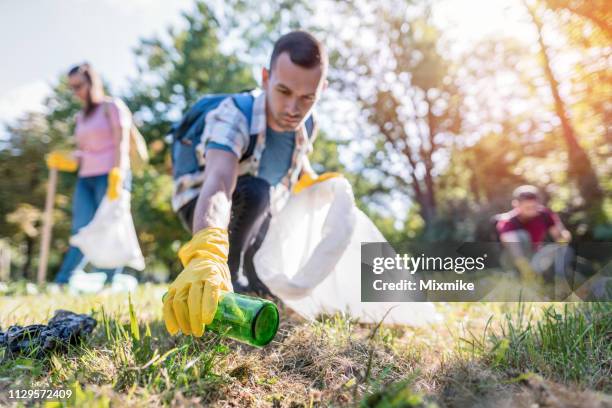 estudiantes de limpieza del parque local de la papelera - plucking fotografías e imágenes de stock