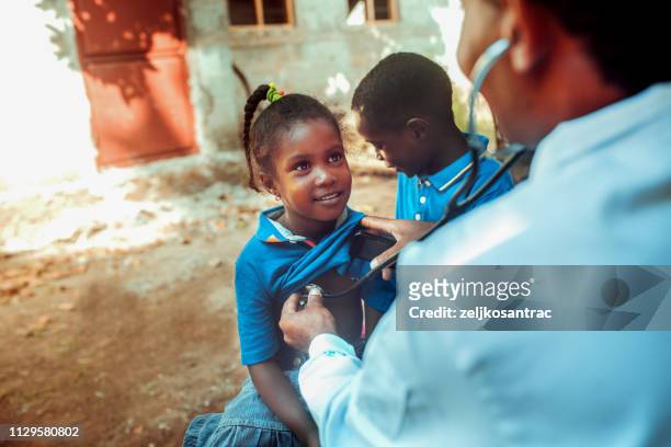 arzt treffen afrikanischen kindes - doctors in africa stock-fotos und bilder