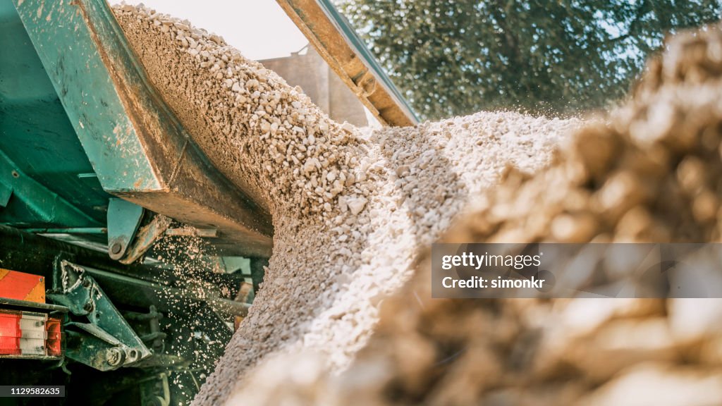 Gravel falling of digger at construction site