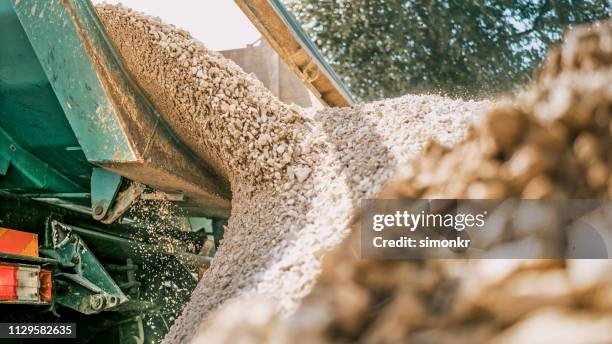 gravel falling of digger at construction site - gravidas imagens e fotografias de stock