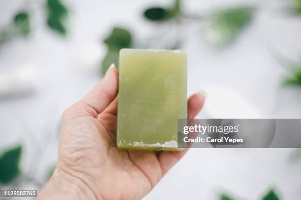 woman hand holding handmade green soap - white bar of soap stock pictures, royalty-free photos & images