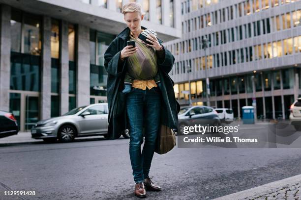 single mother walking with baby while using smartphone - family on the move stock pictures, royalty-free photos & images