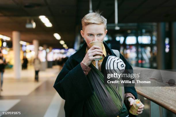 single mother drinking coffee while out with baby - baby carrier outside bildbanksfoton och bilder