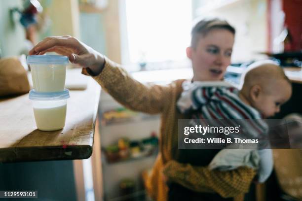 single mother preparing milk for her baby - mother son milk imagens e fotografias de stock