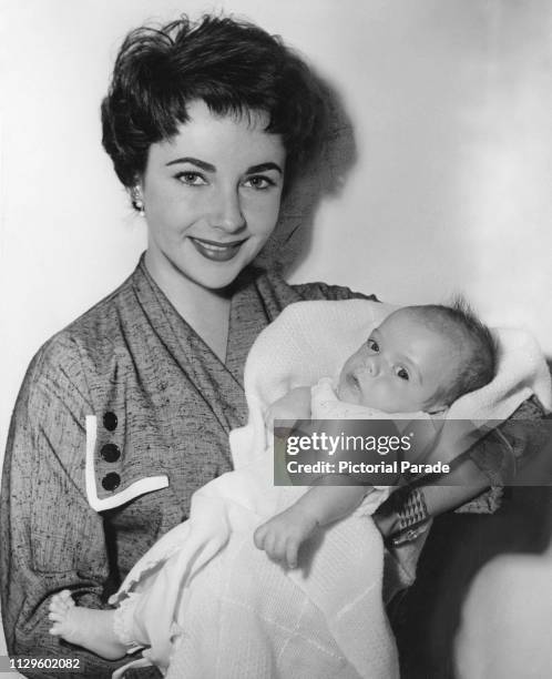 British-born American actress Elizabeth Taylor holding her baby son, Michael Howard Wilding, circa April 1953. The baby is Taylor's first child with...