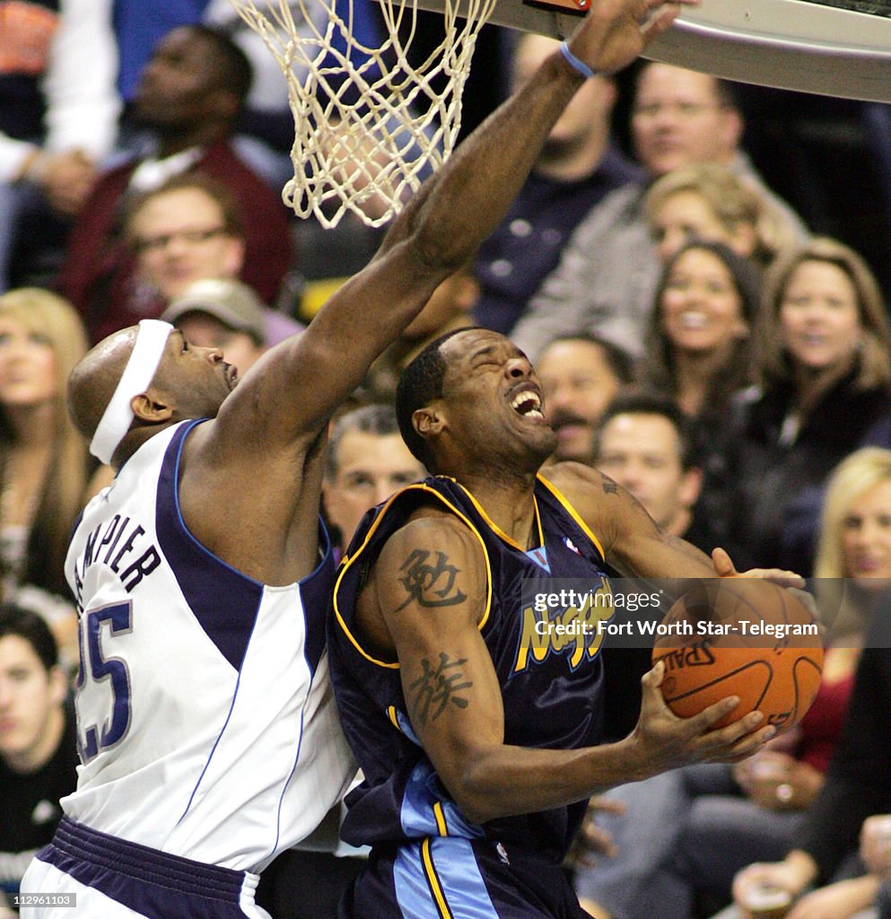 The Dallas Mavericks' Erick Dampier (left) fouls Denver Nugg