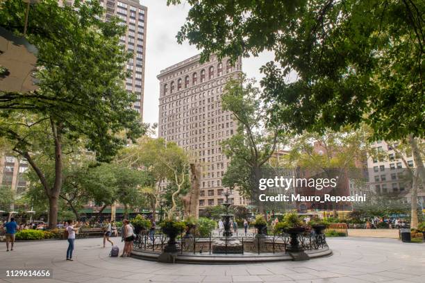 menschen gehen und sitzen auf bänken im sommer im madison square park in midtown manhattan, new york city, usa - madison square park stock-fotos und bilder