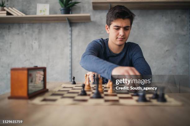 tiener schaken alleen - playing chess stockfoto's en -beelden