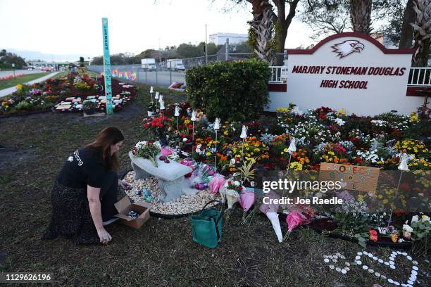 Suzanne Devine Clark visits a memorial setup at Marjory Stoneman Douglas High School for those killed during a mass shooting on February 14, 2019 in...