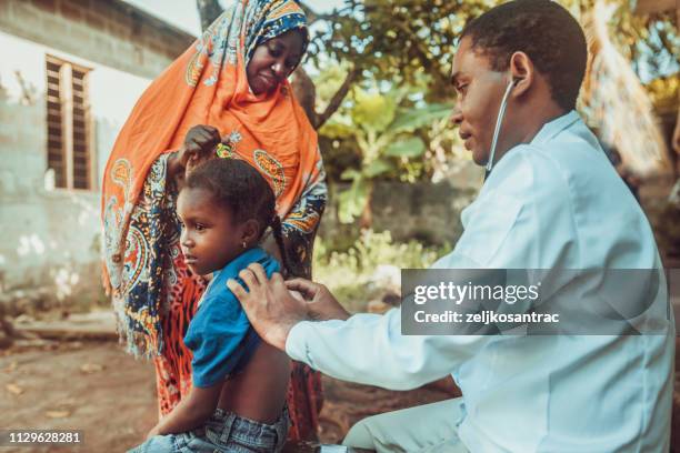 médico conoce a niño africano - áfrica fotografías e imágenes de stock