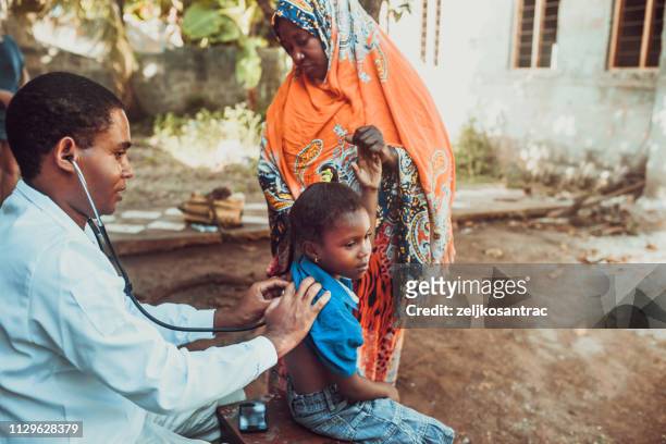 medico incontra bambino africano - medical examination of young foto e immagini stock