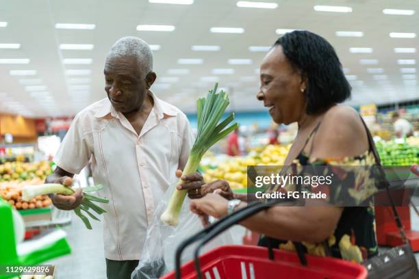 afro senior couple at the farmer's market - older black people shopping stock pictures, royalty-free photos & images