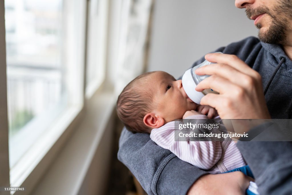 Daddy feeding newborn baby