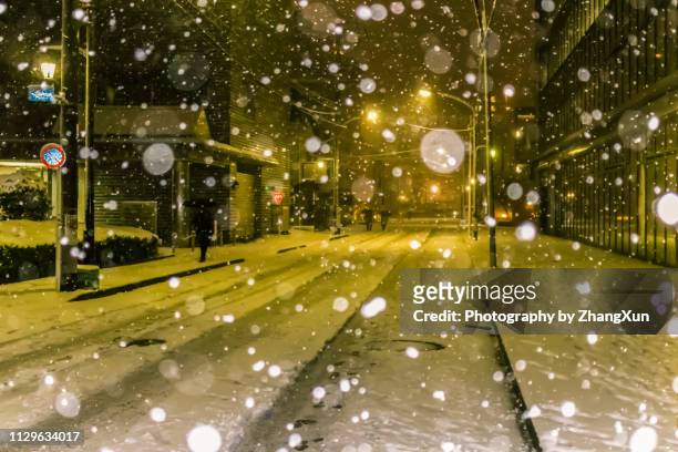 snow is falling in tokyo downtown street at night at winter, japan. - snow in tokyo ストックフォトと画像