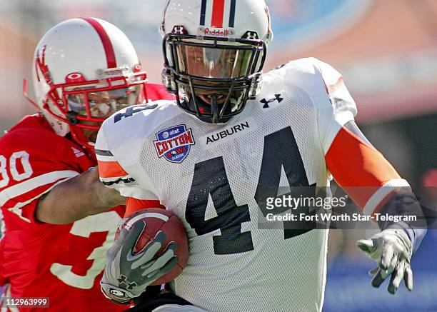 Auburn tailback Ben Tate tries to avoid the tackle by Nebraska Cornhuskers Tierre Green after a long run in the third quarter during the Cotton Bowl...