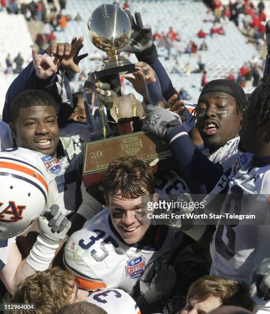 Auburn Tigers players celebrate with the Field Scovell Trophy after defeating the Nebraska Cornhuskers 17-14 in the Cotton Bowl Classic in Dallas,...