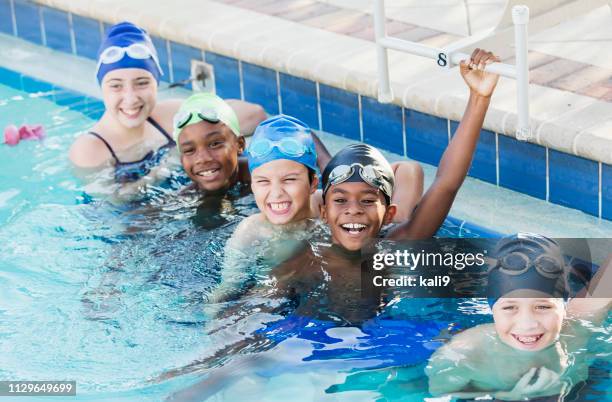 niños multiétnicos en el equipo de natación en piscina - niño bañandose fotografías e imágenes de stock