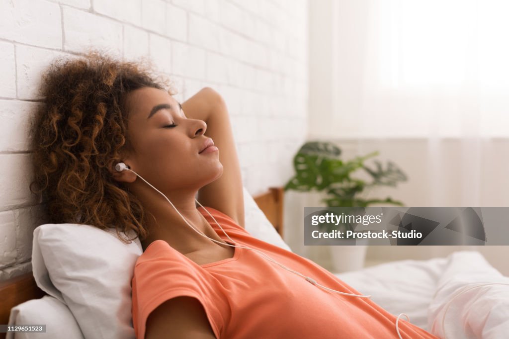 African-american woman relaxing and listening to music