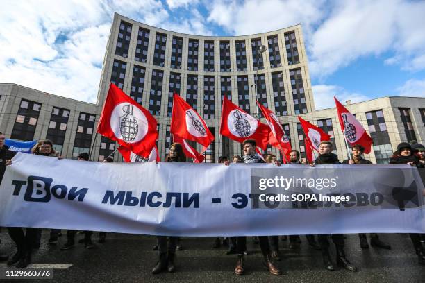 Participants are seen holding a banner and flags during the protest. Participants in an opposition rally in central Moscow protest against tightening...