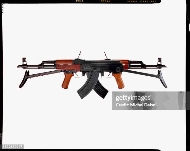 View of two AKM assault rifles, both with an attached magazines, seen against a white background, New York, New York, March 9, 1994. The photo was...