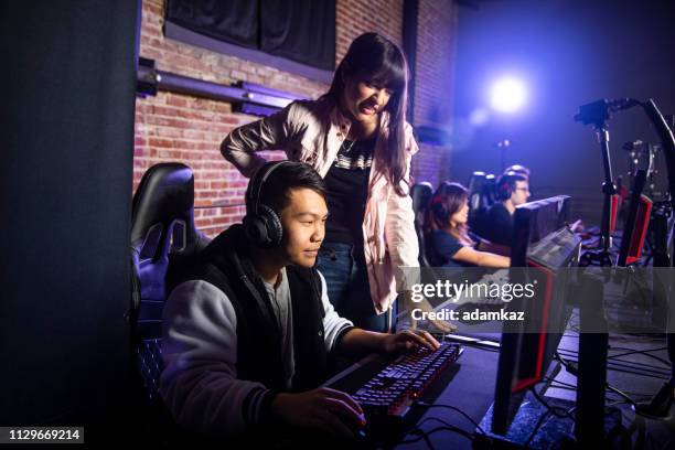 junge frau einen mann spielen esports coaching - spielregeln stock-fotos und bilder