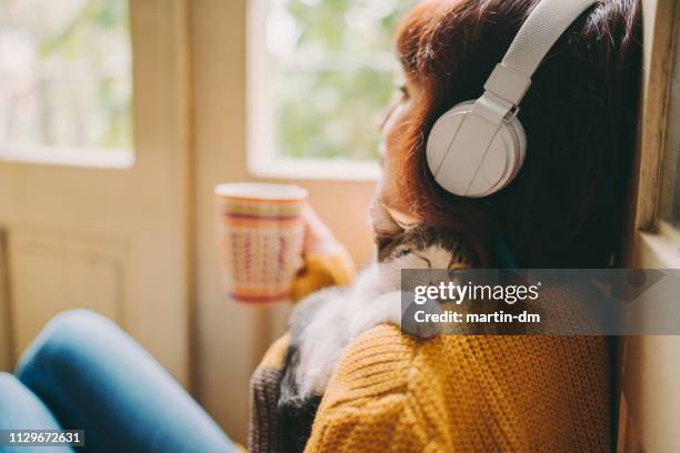gemütliches zuhause - woman listening to music stock-fotos und bilder