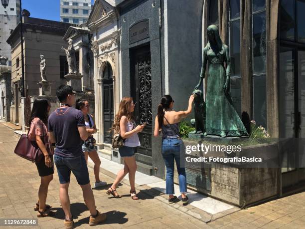 toeristen overweegt standbeeld in recoleta cemetery in buenos aires - la recoleta cemetery stockfoto's en -beelden