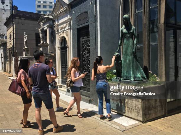 tourists contemplating statue in recoleta cemetery, buenos aires - la recoleta cemetery stock pictures, royalty-free photos & images