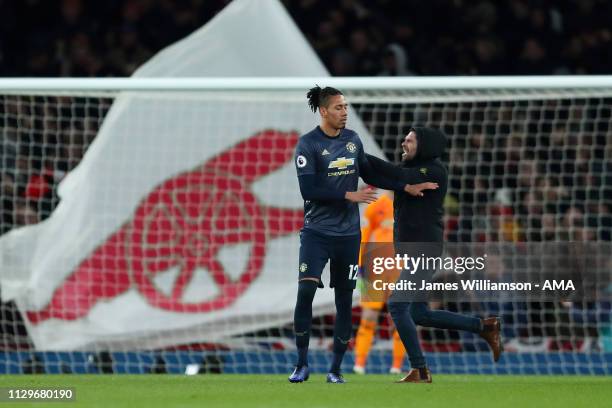Fan runs onto the pitch and attacks Chris Smalling of Manchester United during the Premier League match between Arsenal FC and Manchester United at...