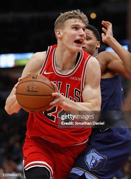 Lauri Markkanen of the Chicago Bulls drives past Ivan Rabb of the Memphis Grizzlies at the United Center on February 13, 2019 in Chicago, Illinois....