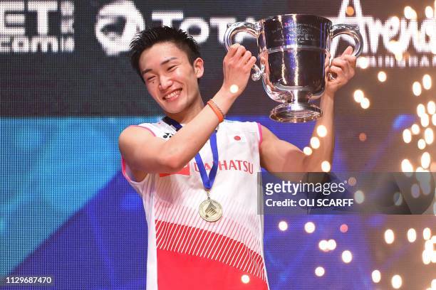 Japan's Kento Momota poses with his trophy after victory over Denmark's Viktor Axelsen in the mens singles final of the All England Open Badminton...